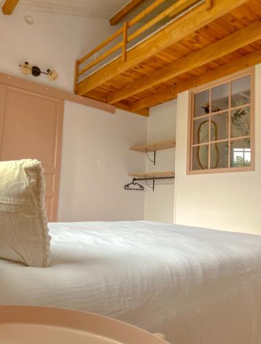 une chambre avec un lit blanc et une fenêtre dans l'établissement Un petit bout de Louisiane chambre d'hôtes avec Piscine et Petit Déjeuner, à Chantonnay