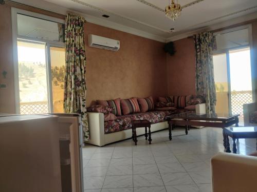 a living room with a couch and a table at HOTEL FADOUA in Moulay Yacoub