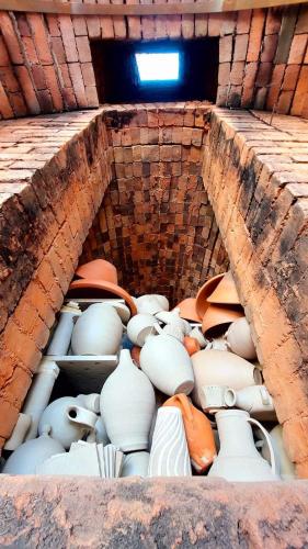 a pile of white pottery in a brick wall at Orion Guesthouse Telhado in Fundão