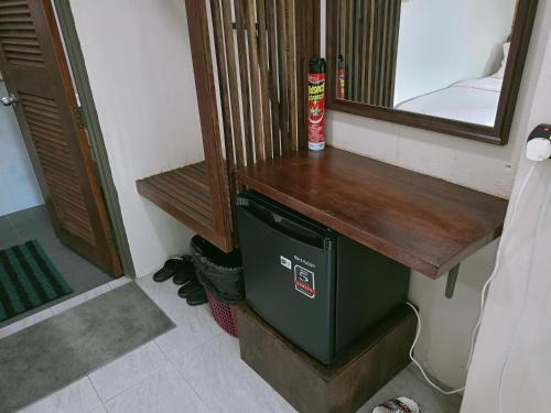 a bathroom with a green trash can next to a mirror at Naura Roomstay in Kuala Tahan