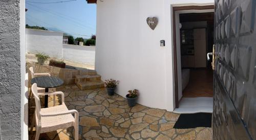 patio z 2 krzesłami i stołem obok drzwi w obiekcie NoMad House-entire house at your disposal,4 guests w mieście Berat