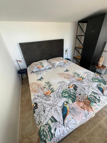 - une chambre avec un grand lit et une couette colorée dans l'établissement Ô’ Vue Mer Panoramique Zen, à Bandol