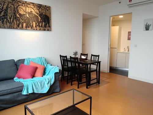 a living room with a couch and a table at Harmonee Homes at The Hub SS2, PJ in Petaling Jaya