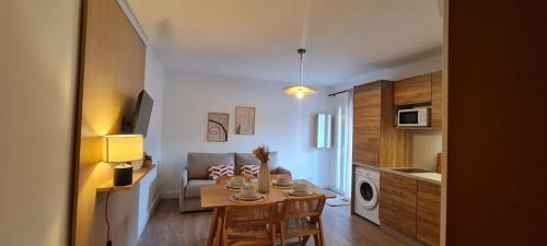 eine kleine Küche und ein Wohnzimmer mit einem Tisch und Stühlen in der Unterkunft Limiria Studio in Santa-Maria-Poggio