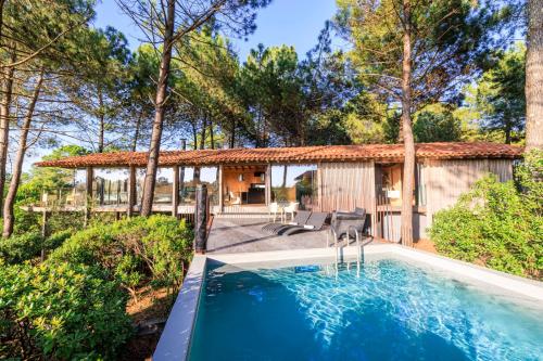une piscine devant une maison dans l'établissement Villa Lodge Plage et golf à pieds, à Moliets-et-Maa