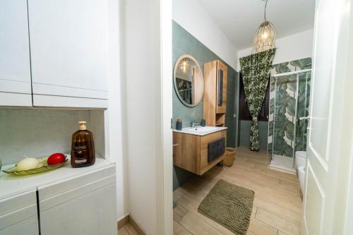 un bagno con lavandino e specchio di Vesuvius Apartament a Scafati