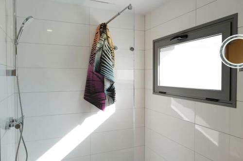 a television and two umbrellas hanging on a wall at FEEL GOOD Ferienapartment mit Meerblick und Pool in Santa Úrsula