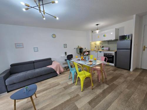un salon avec un canapé, une table et des chaises dans l'établissement MarshMallow Toulouse proche aéroport, Airbus et Zenith, à Toulouse