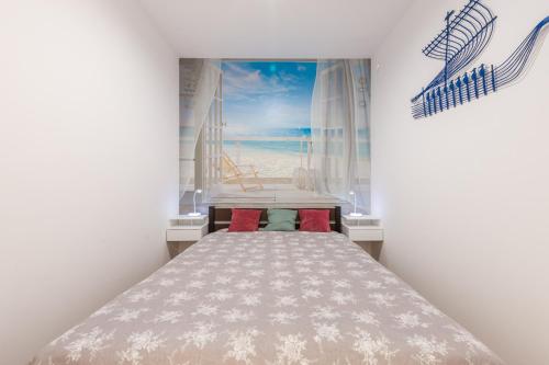 a bedroom with a bed with a painting of a pier at Ustka Apartament Na Wydmie 4 in Ustka