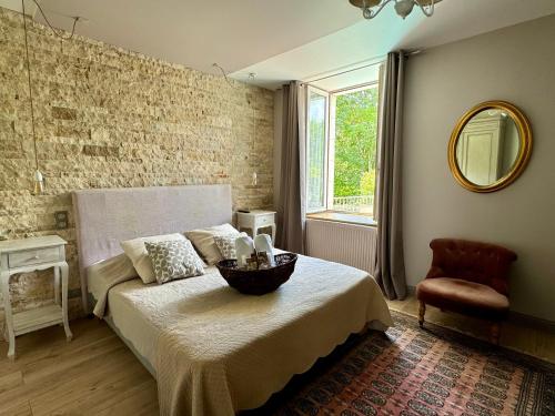 une chambre avec un lit, une chaise et un miroir dans l'établissement Domaine Borgnat, à Escolives-Sainte-Camille
