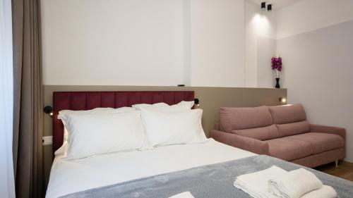 a bedroom with a bed and a pink chair at Circle Tirana City Center in Tirana