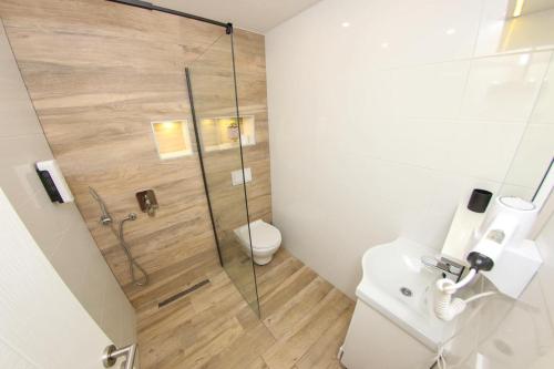 a bathroom with a toilet and a glass shower at Apartman LIKE Sarajevo 2 in Sarajevo