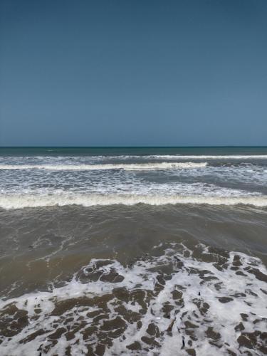 a beach with footprints in the sand and the ocean at La playita in Los Córdobas