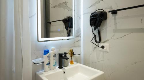 a bathroom with a sink with a mirror and a phone at Circle Tirana City Center in Tirana