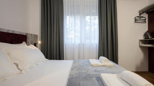 a bedroom with a white bed with a window at Circle Tirana City Center in Tirana