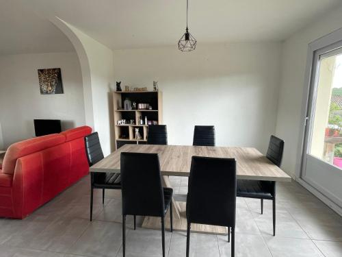- une salle à manger avec un canapé rouge, une table et des chaises dans l'établissement Gîte du samedy, au Saint