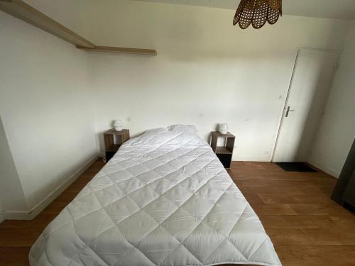 - un lit blanc dans une chambre avec 2 tables de nuit dans l'établissement Gîte du samedy, au Saint