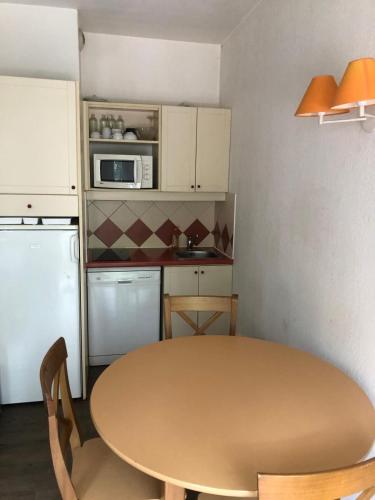 une petite cuisine avec une table et un micro-ondes dans l'établissement Appartement Chamonix, à Chamonix-Mont-Blanc