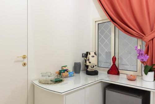 een keuken met een aanrecht, een raam en een tafel bij Private Suite Intermezzo in Napels