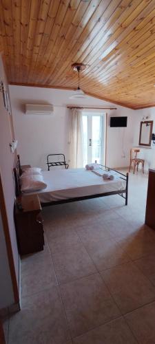 a bedroom with a large bed with a wooden ceiling at Hector's Studios in Alikanas