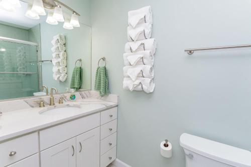 a white bathroom with a sink and a mirror at 127th Street OCMD Condo in Ocean City