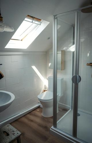 La salle de bains est pourvue de toilettes, d'un lavabo et d'une lucarne. dans l'établissement Le Charron de Sancerre, à Neuilly-en-Sancerre