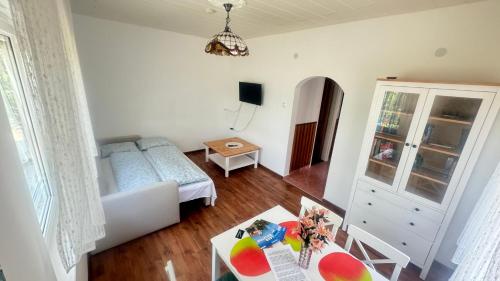 a living room with a bed and a table at Zöldház in Balatonmáriafürdő
