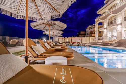 a hotel swimming pool with lounge chairs and umbrellas at Casa Deniso - The Home of Chill in Byala