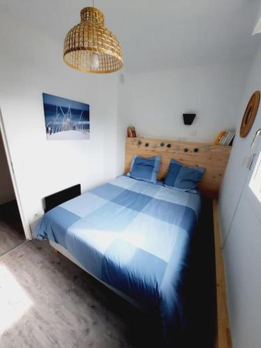 - une chambre avec un lit bleu et un lustre dans l'établissement F3 60m2 dans résidénce, 2 chambres, Garage, à La Grande Motte