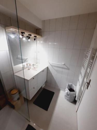 une salle de bain blanche avec un lavabo et un miroir dans l'établissement F3 60m2 dans résidénce, 2 chambres, Garage, à La Grande Motte