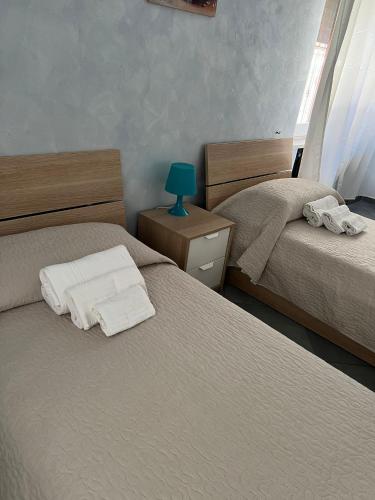 a bedroom with two beds and a blue lamp at Elios in in Tropea