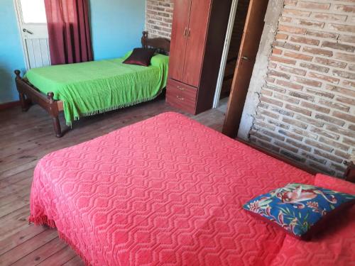 a room with two beds and a brick wall at El Cumpa Bungalow in La Paz