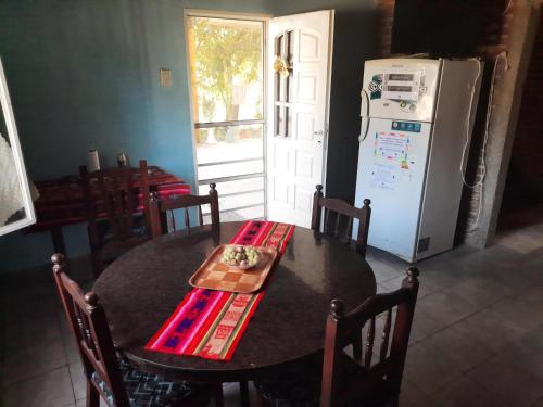 a kitchen with a table and a refrigerator at El Cumpa Bungalow in La Paz