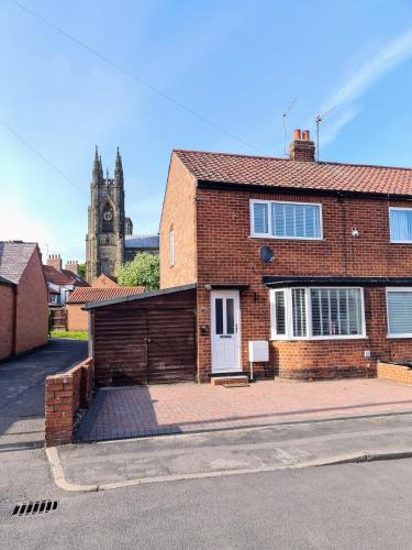 a brick house with a clock tower in the background at Semi detached quite location in Bridlington