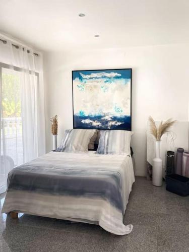 une chambre avec un grand lit avec un tableau au mur dans l'établissement Magnifique villa spacieuse vacance dans le SUD, à Fréjus