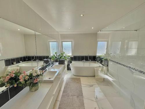 La grande salle de bains est pourvue de 2 lavabos et d'une baignoire. dans l'établissement Magnifique villa spacieuse vacance dans le SUD, à Fréjus
