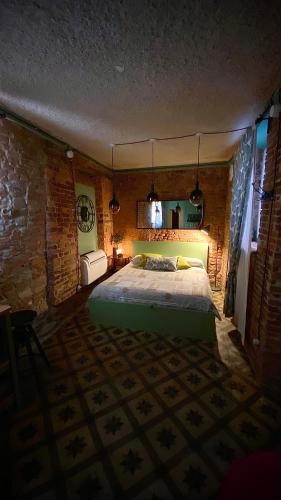 a bedroom with a bed and a brick wall at La Porta Verde in Lucca