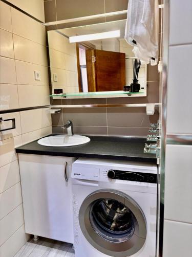 a kitchen with a washing machine and a sink at Altezza Luxury Apartment 11 in Budva