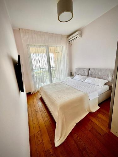 a bedroom with a large bed with a large window at Altezza Luxury Apartment 11 in Budva