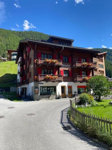 a building with flowers on the balconies on a street at Chalet Annelis Apartments in Zermatt