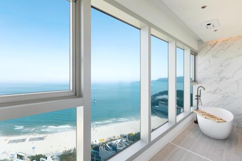 a bathroom with a view of the ocean at NewCZ Haeundae Residence in Busan