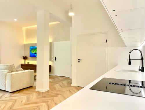 a kitchen and living room with a sink and a couch at Loft am Lech I Rollstuhlgerecht I Tiefgarage I Küche I Terrasse in Füssen