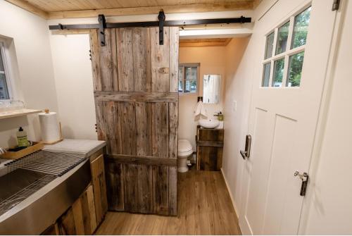 a bathroom with a wooden door and a toilet at Schuyler Yacht Basin in Schuylerville