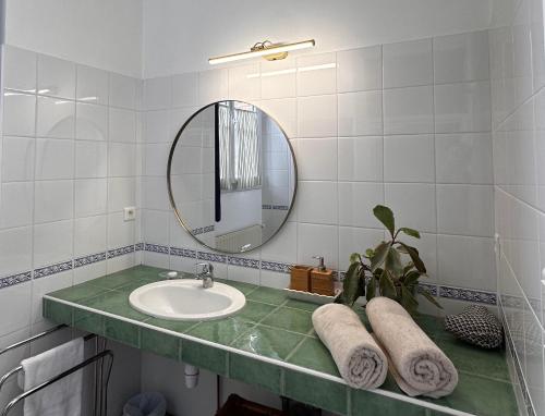 une salle de bain avec un lavabo et un miroir dans l'établissement Cottage dans ancienne école de 1850 - 2 à 4 personnes, à Missillac