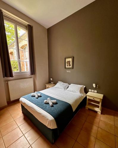 une chambre avec un lit avec deux serviettes dessus dans l'établissement Cottage dans ancienne école de 1850 - 2 à 4 personnes, à Missillac