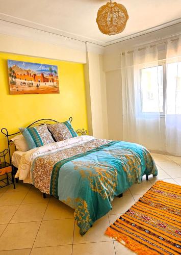 a bedroom with a bed and a yellow wall at Plein centre, plage & souks à deux pas ! in Agadir