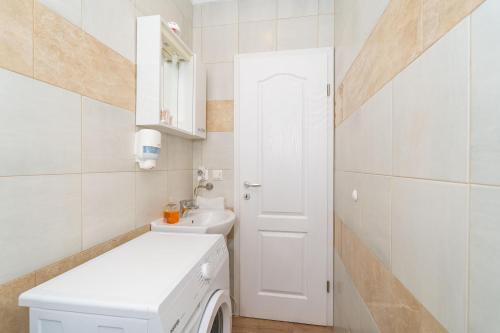 een witte badkamer met een wasmachine en droger bij House Terra Madre in Gruda