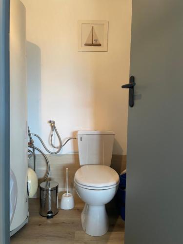 a bathroom with a white toilet and a sink at Plage des Sables d'or in Broons