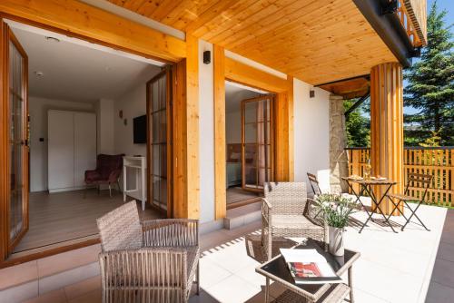 a patio with chairs and a table on a deck at Apartamenty Mikołaj Zakopane in Kościelisko