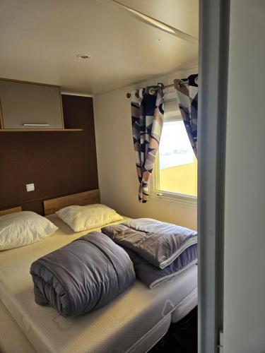 une chambre avec deux lits et une fenêtre dans l'établissement Mobilhome, à Quend